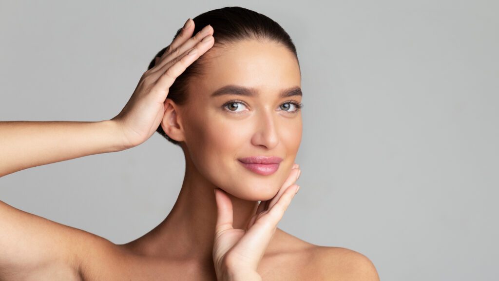 A fresh-faced woman with flawless skin, emphasizing safe makeup application after facial procedures. Mark A. Deuber M.D -Dallas, Texas